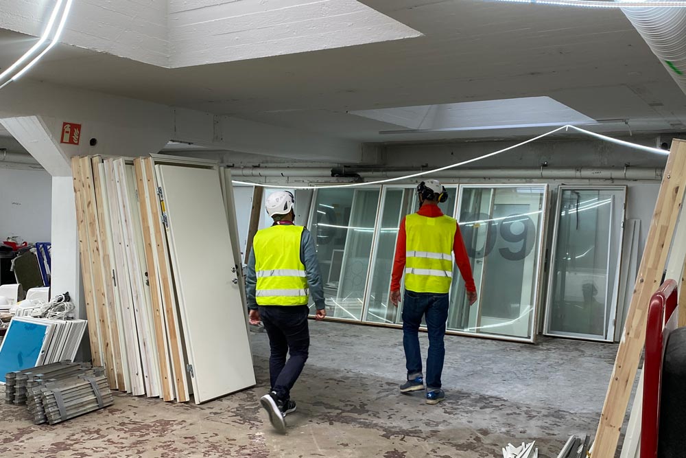 Två besiktningsmän går genom en inomhusbyggarbetsplats